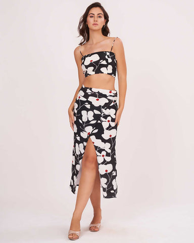 Full view of the black floral spaghetti strap co-ord set with the model standing straight, showing skirt length and fit.