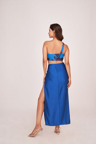 Back view of a blue satin co-ord set with a one-shoulder top and skirt featuring a back zip closure
