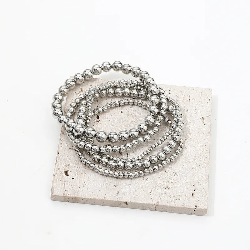 This versatile four-piece silver anklet set features a combination of minimalist chains and patterned beads, an ideal accessory for creating a curated, boho-chic look for summer festivals.