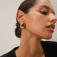 A beautiful example of modern jewelry design, these polished gold-toned earrings feature a liquid-metal finish that effortlessly elevates both casual daytime basics and elegant evening wear.