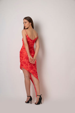 Back view of red floral high-low dress showing asymmetric hem and spaghetti straps.
