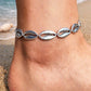 A bright sterling silver anklet featuring detailed, high-shine cowrie shell charms, perfect for adding a polished beachy vibe to your summer evening look.