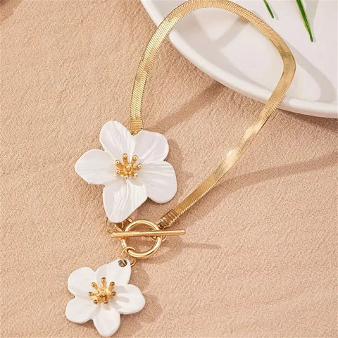 A dainty gold-toned anklet featuring intricate white enamel flowers with golden centers, perfect for adding a fresh, feminine touch to a spring wedding or a garden party.