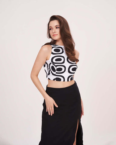 Sleeveless white crop top featuring a bold black abstract geometric print and a high round neckline.